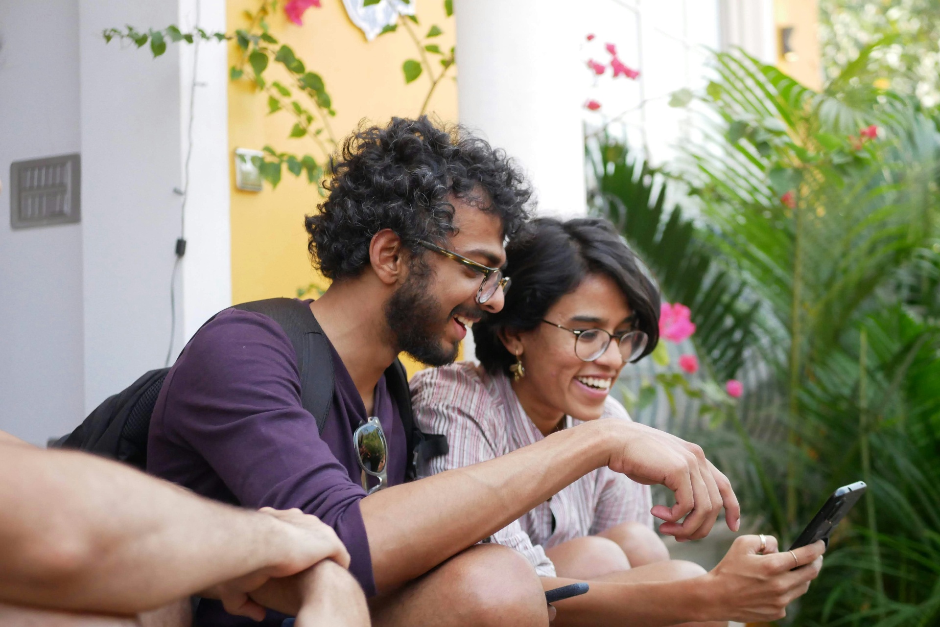 Two people smiling and looking at a phone together